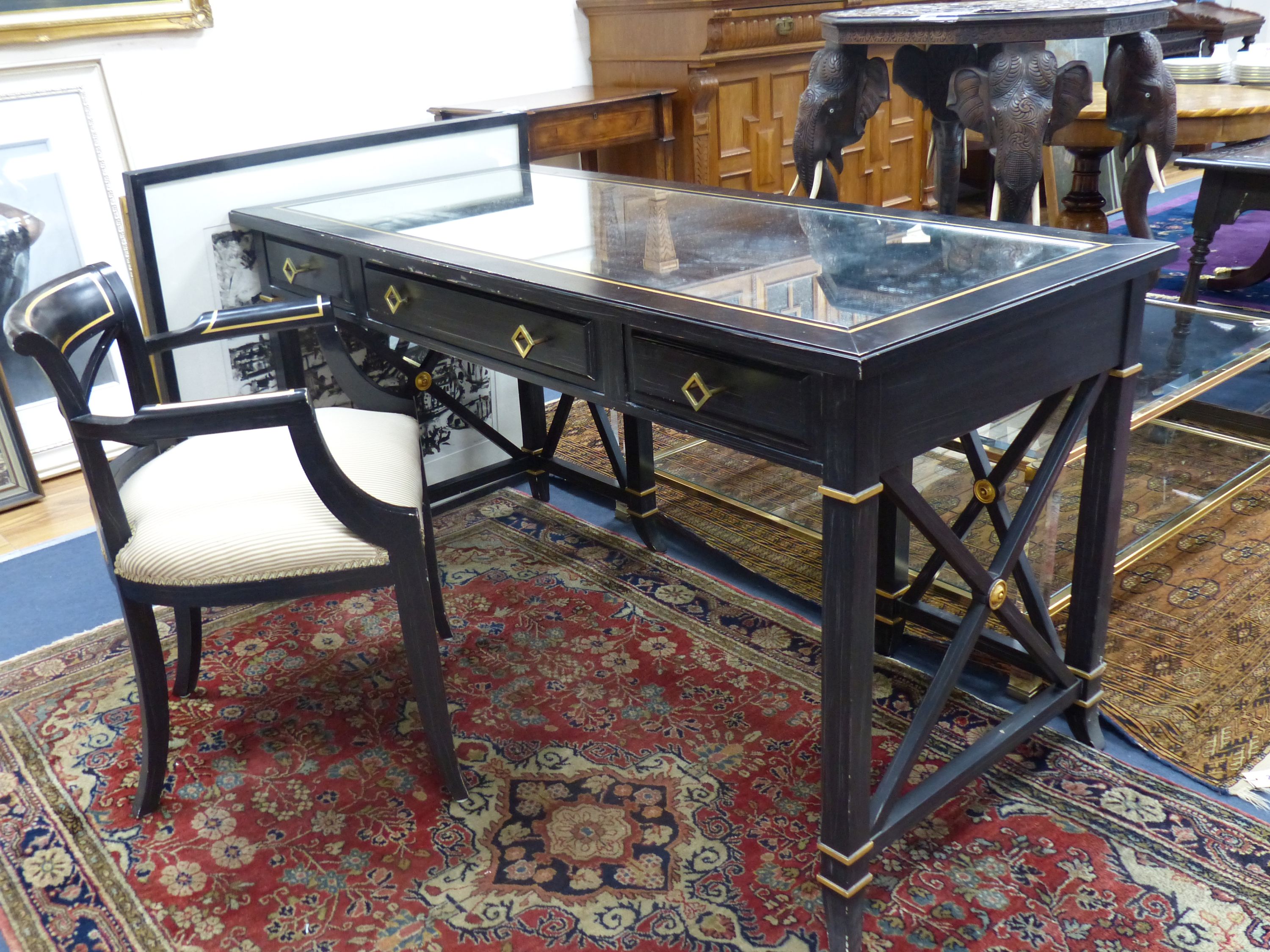 A Regency style ebonised mirrored dressing table, width 139cm, depth 64cm, height 75cm and elbow chair